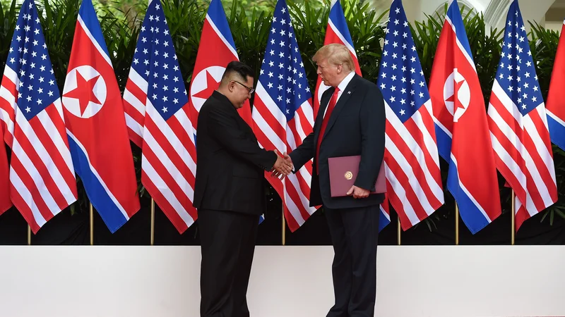 Fotografija: Severnokorejski voditelj Kim Džong Un se rokuje s predsednikom ZDA Donaldom Trumpom. FOTO Anthony Wallace / POOL / AFP