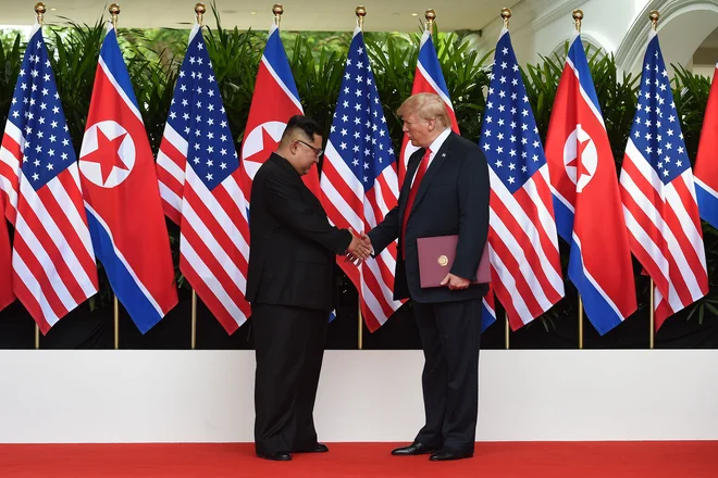 Severnokorejski voditelj&nbsp; Kim Džong Un se rokuje s&nbsp; predsednikom ZDA&nbsp; Donaldom Trumpom.&nbsp; FOTO Anthony Wallace / POOL / AFP