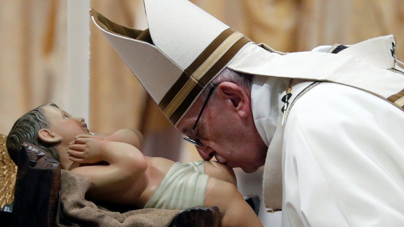 Fotografija: Papež Frančišek je med mašo na božični večer poljubljal kip Jezusa. FOTO: Max Rossi/Reuters