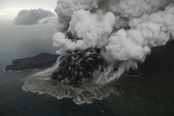 Ob izbruhu je velik del kraterja ognjenika zdrsnil v morje. FOTO: AP