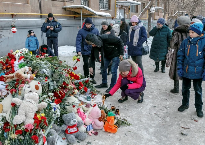 Ljudje se poslavljajo od žrtev. FOTO: Stringer Reuters