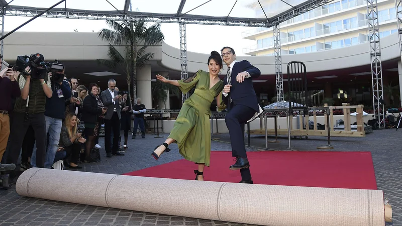 Fotografija: Takole sta igralka Sandra Oh in komik Andy Samberg razvila rdečo preprogo, po kateri se bodo sprehodili zvezdniki. FOTO: AFP