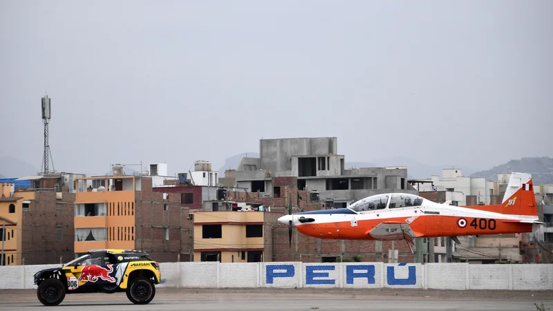 Fotografija: Portret Francoza Sebastiena Loeba v svojem Peugeotu med ekshibicijsko dirko proti letalu pred uradnim začetkom relija Dakar v Peruju. Foto Franck Fife Afp