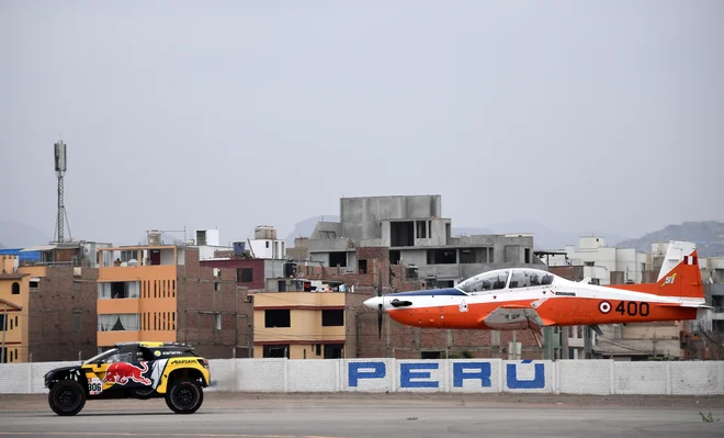 Portret Francoza Sebastiena Loeba v svojem Peugeotu med ekshibicijsko dirko proti letalu pred uradnim začetkom relija Dakar v Peruju. Foto Franck Fife Afp