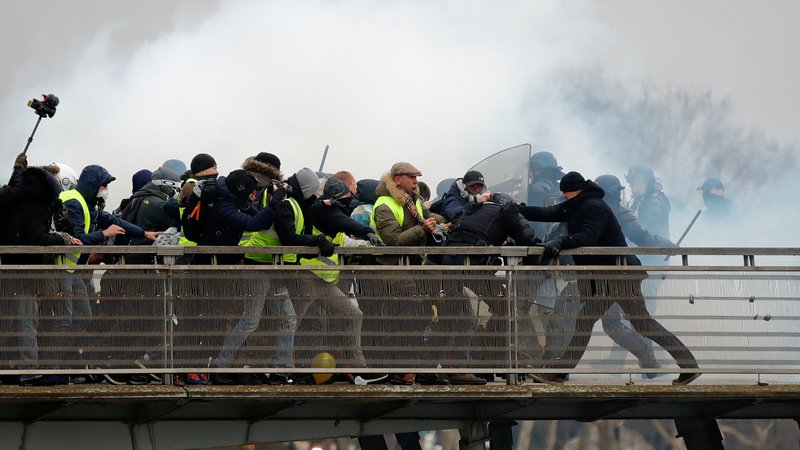 Fotografija: Bivši francoski boksarski prvak Christophe Dettinger (desno) se je skupaj z "rumenimi jopiči" na protestih v Parizu spopadel s policijo. Ta je bil v množici ljudi, ki jim je policija poskušala preprečiti prehod preko mostu Leopold-Sedar-Senghor. Po poročanju francoskih medijev je bivši šampion poskušal zaščititi žensko v gneči, pri tem pa ga je zmotilo posredovanje policije.
Foto Gonzalo Fuentes Reuters