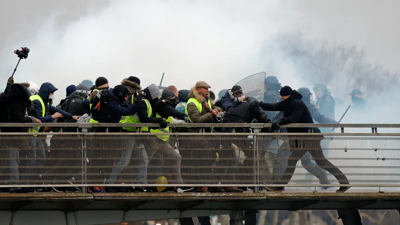 Fotografija: Bivši francoski boksarski prvak Christophe Dettinger (desno) se je skupaj z "rumenimi jopiči" na protestih v Parizu spopadel s policijo. Ta je bil v množici ljudi, ki jim je policija poskušala preprečiti prehod preko mostu Leopold-Sedar-Senghor. Po poročanju francoskih medijev je bivši šampion poskušal zaščititi žensko v gneči, pri tem pa ga je zmotilo posredovanje policije.
Foto Gonzalo Fuentes Reuters