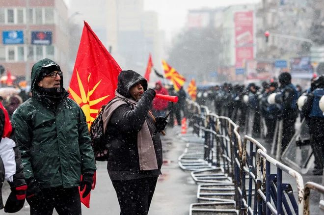 Protestov proti spremembi imena države se je v sredo pred močno zastraženo stavbo parlamenta udeležila manjša skupina ljudi. FOTO: AFP