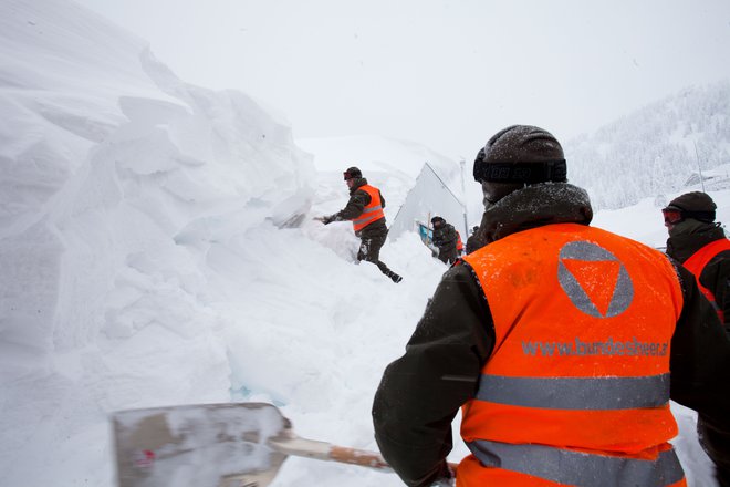 Vojaki avstrijskih oboroženih sil pomagajo pri izkopavanju na nadmetrski višini 1380 metrov. FOTO: Alex Halada/Afp