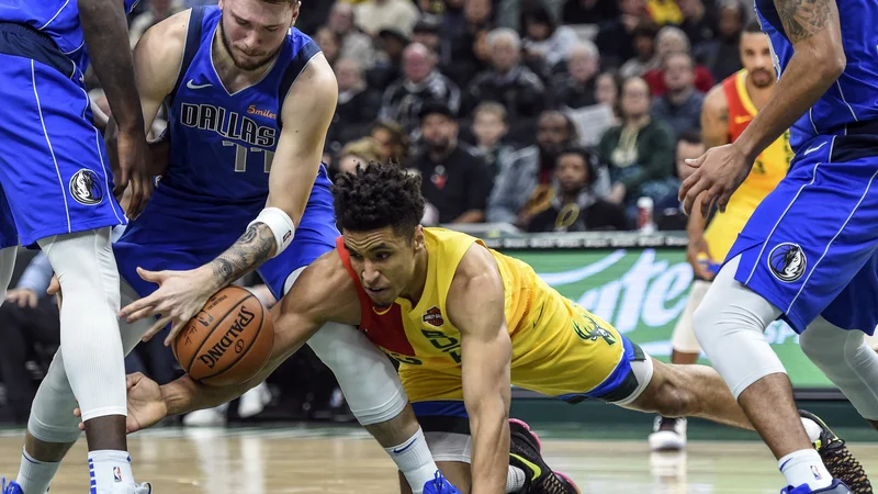 Fotografija: Luka Doncic se je takole boril za žogo z Malcolmom Brogdonom. FOTO: Reuters