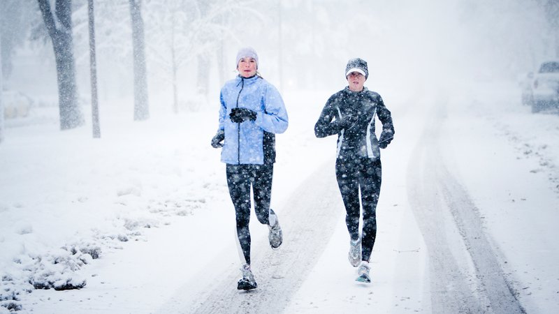 Fotografija: Kara Roy (black jacket) and Jennifer Lee (blue jacket) run down Mountain Avenue in a snowstorm.
