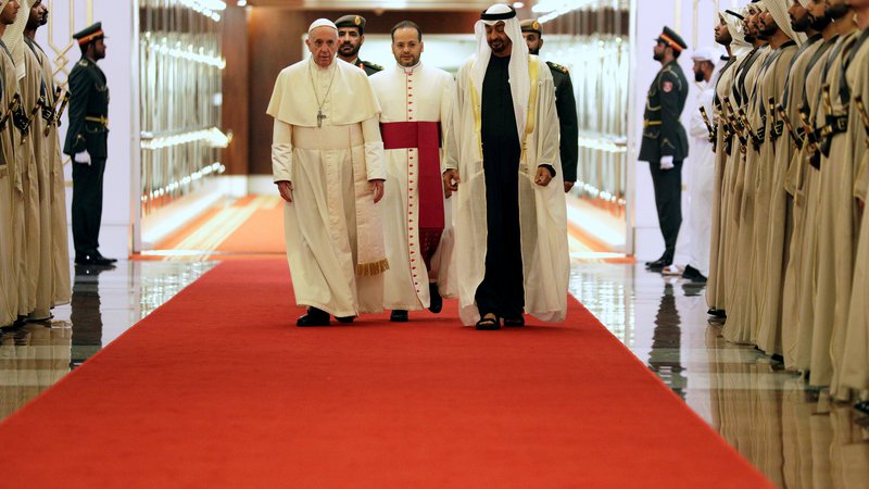 Fotografija: Papežu Frančišku je ob prihodu v Abu Dabi izrekel dobrodošlico princ šejk Mohamed bin Zajed al Nahjan (skrajno desno). FOTO: Andrew Medichini/Pool via Reuters