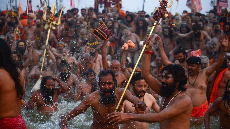 Fotografija: Indijski sveti možje goli skočejo v vodo svete reke Sangama, na sotočju Gangesa, Yamune in mitološke reke Saraswati v Allahabadu. Milijoni hindujskih romarjev se je danes potopilo v sveto reko na verskem festivalu Kumbha Mela. Foto Sanjay Kanojia Afp