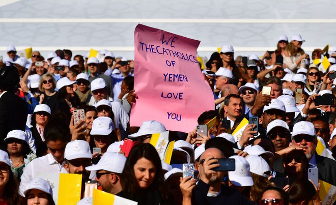Manjša skupina ljudi je v rokah držala plakat z napisom: »Katoličani iz Jemna te ljubimo!« FOTO: Giuseppe Cacace/AFP