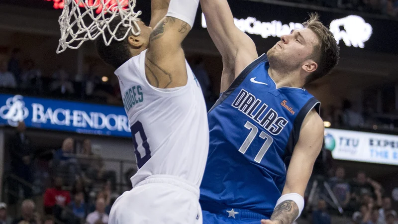 Luki Dončiću ni šlo vse kot po maslu, a je vseeno tekmo zaznamoval z novim trojnim dvojčkom. Takole ga je pri poskusu &quot;zabijanja&quot; z blokado ustavil branilec moštva Charlotte Miles Bridges. FOTO: Usa Today Sports