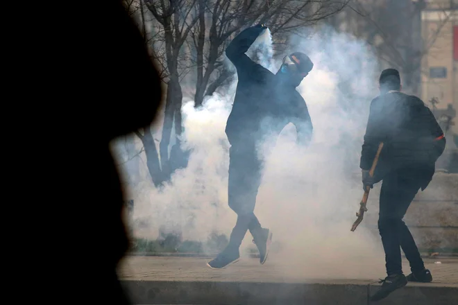 Francoska&nbsp;policija je granate s solzivcem uporabila v bližini narodne skupščine, kjer so protestniki poskušali odstraniti varnostno ograjo ter so na policijo metali predmete. FOTO: Alex Martin/Afp