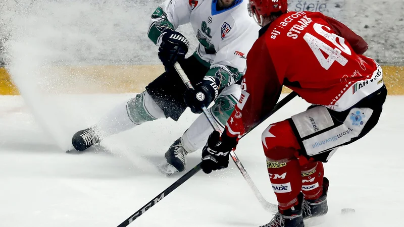 Fotografija: Kot ponavadi je bilo v derbiju precej zanimivih dvobojev, kot je ta med Olimpijinim napadalcem Žanom Jezovškom in Jeseničanom Nejcem Stojanom. FOTO Roman Šipić/Delo