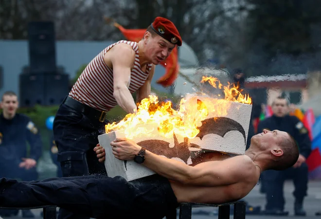 Beloruski specialci ministrstva za notranje zadeve izvajajo točko moči in vzdržljivosti na dogodku Zimske radosti v vojaški bazi v Minsku.&nbsp;Foto Vasily Fedosenko Reuters