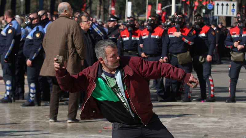 Fotografija: Protestniki pred vladnim poslopjem so policiste obmetavali s kamenjem. FOTO: Florion Goga/Reuters