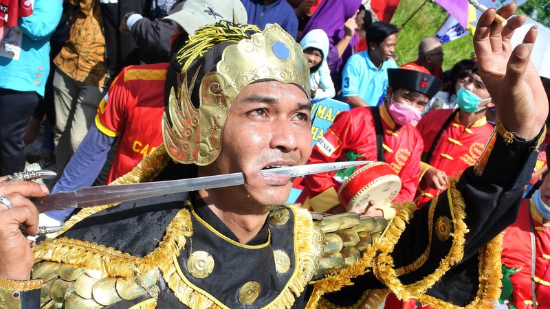 Fotografija: Indonezijec na paradi festivala Cap Go Meh v Singkawangu izvaja prebadanje meča skozi lice. Kitajski Indonezijci s festivalom označijo konec lunarnega novega leta. Foto Daddy Cavalero Afp