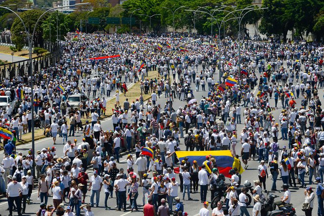 Samooklicani začasni predsednik Guaido je sodržavljane pozval, naj se udeležijo množičnih protestov po vsej državi, da bi vojsko pozvali, naj pomoč spusti v državo. Na fotografiji množica njegovih podpornikov v Caracasu FOTO: AFP