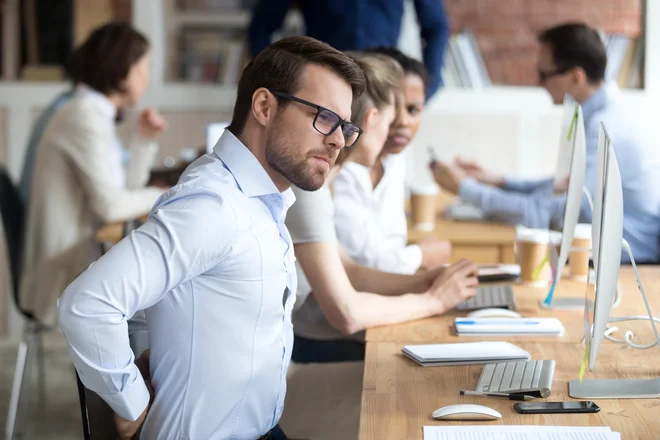 Večkrat ko vstanemo, se malo sprehodimo, naredimo vajo, ki sprosti prej napete mišice, manj tvegamo bolečino v predelu hrbta. FOTO: Shutterstock