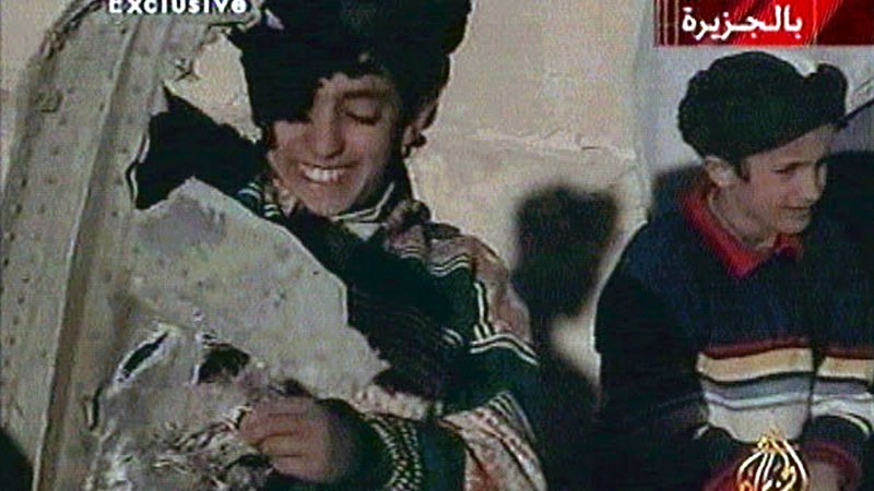 Fotografija: Deček na levi strani fotografije, ki v rokah drži razbitine ameriškega helikopterja, naj bi bil Hamza bin Laden. FOTO: Reuters