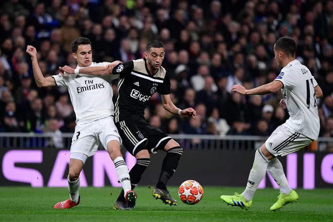 Ajaxov napadalni zvezni igralec Hakim Ziyech je ob Nachu Fernandezu in Lucas Vazquez našel pot do prvega gola v madridskem dvoboju. FOTO: AFP