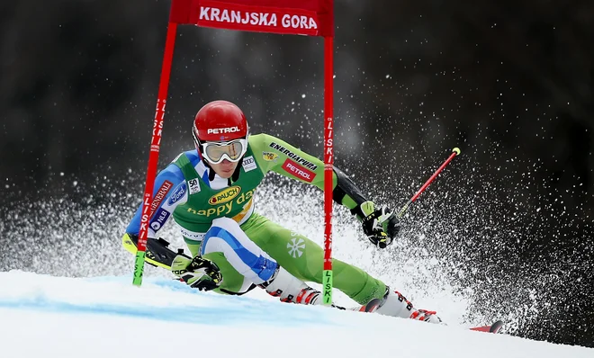 Izkušeni Kranjskogorci se trudijo s pripravo terena, na katerem bo Žan Kranjec v soboto napadal stopničke. FOTO: Matej Družnik/Delo