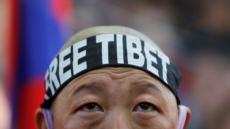 Fotografija: Podporniki dalajlame so prepevali pesmi in molili, nekateri so imeli na obrazih napisano »svoboden Tibet«. FOTO: Adnan Abidi/Reuters