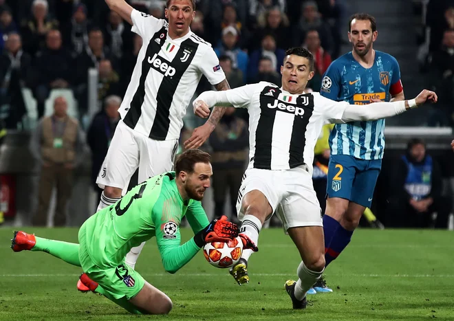 Kako neprijetnih 90 minut bo čakalo Jana Oblaka, je Cristiano Ronaldo napovedal že v 2. minuti, ko je šel &raquo;na polno&laquo; v našega vratarja. FOTO: AFP