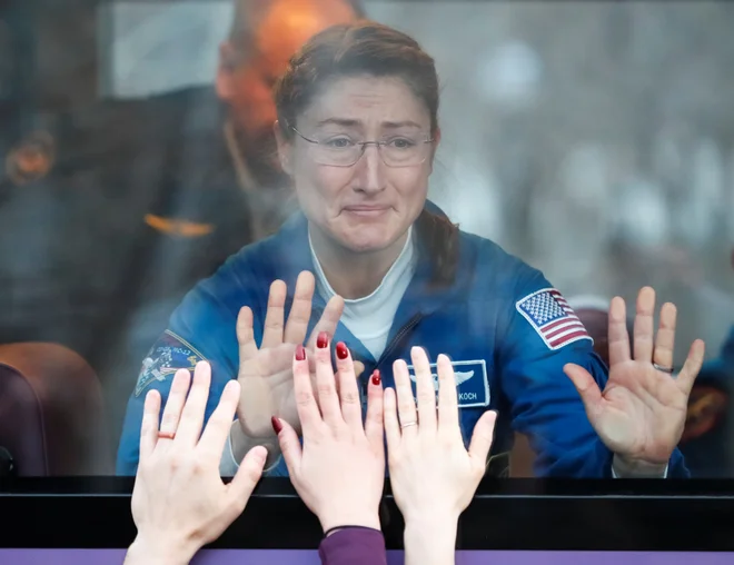Članica posadke mednarodne vesoljske postaje (ISS) Christina Koch iz ZDA se v avtobusu poslavlja od najbližjih pred poletom na kozmodru Baikonur vKazahstanu.&nbsp;Foto Shamil Zhumatov Reuters