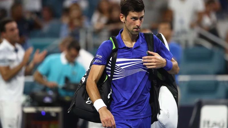 Fotografija: Novak Đoković je z igrišča odkorakal sklonjene glave. FOTO: Julian Finney/AFP