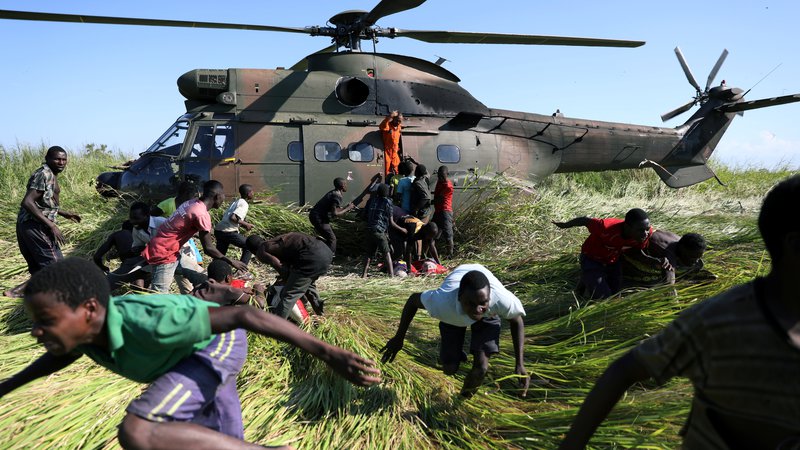 Fotografija: Blizu mozambiškega mesta Beira so južnoafriške obrambne sile (SANDF) s helikopterjem dostavile osnovna živila in vodo za okoliške ljudi, ki so v poplavah ostali brez vsega. Foto Siphiwe Sibeko Reuters