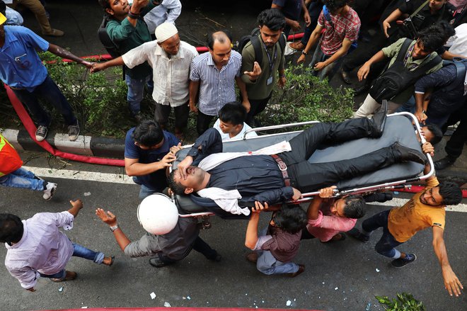 Oseba, ki so jo rešili iz goreče stolpnice v Dhaki. FOTO: Mohammad Ponir Hossain/Reuters