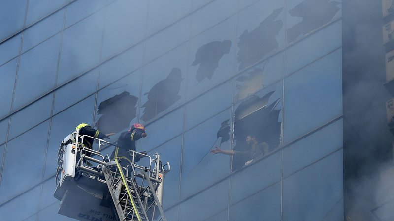 Fotografija: Požar je v stolpnici z izjemno pomanjkljivimi protipožarnimi ukrepi presenetil več sto uslužbencev. FOTO: Munir Uz Zaman/AFP
