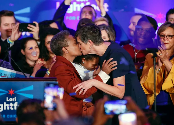 Lori Lightfoot (L), prva gejevska afroameriška ženska izvoljena za županjo Chicaga, tretjega največjega mesta v Ameriki, je ob razglasitvi rezultatov volitev poljubila svojo ženo Amy Eshleman. V torek so meščani Chicaga na volitvah zaupali mandat politični začetnici reševanje težkih problemov gospodarske neenakosti in nasilja. 56-letna Lori Lightfoot je nekdanja zvezna tožilka in odvetnica.&nbsp;Foto Kamil Krzaczynski Afp