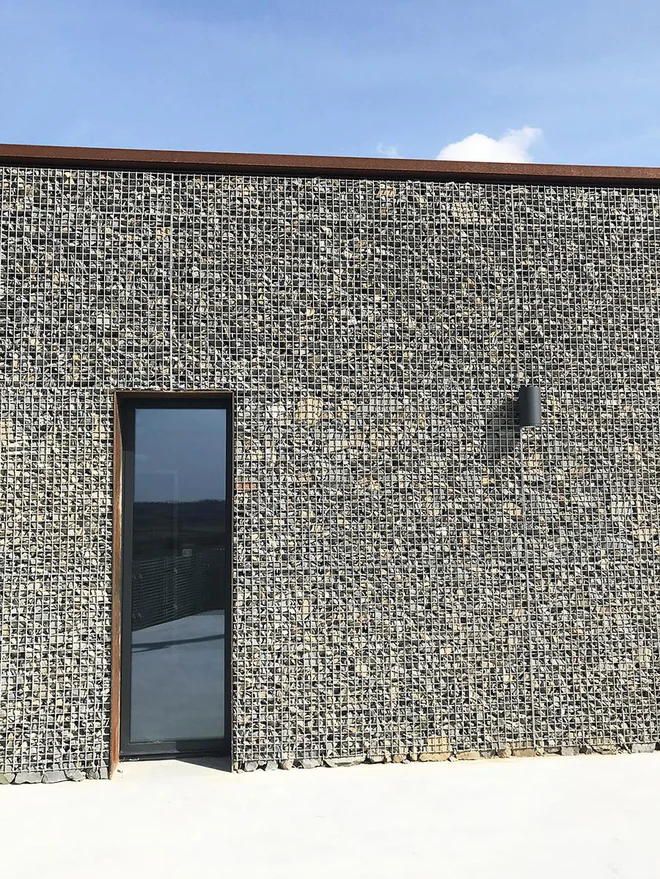 V gabione, ki spominjajo na tradiconalne škarpe, so nasuli zdrobljen kamen, ki so ga odkopali na lokaciji. FOTO: Arhiv biroja Plusminus30