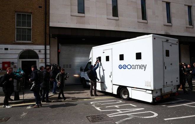 Predstavniki medijev, zbrani okoli transportnega vozila, ki je prispelo na westminstrsko sodišče. FOTO: Hannah Mckay/Reuters