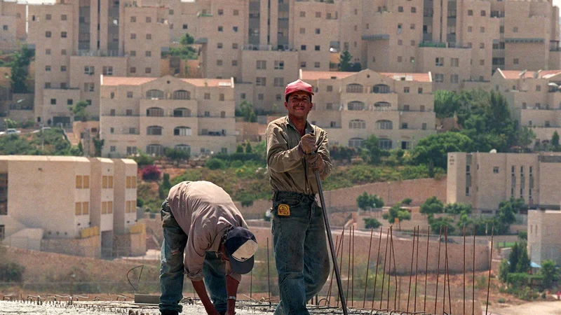 Fotografija: Palestinska delavca ob gradnji naselja za judovske priseljence v kraju Ma'ale Adumim na Zahodnem bregu. FOTO: Rula Halawani/Reuters