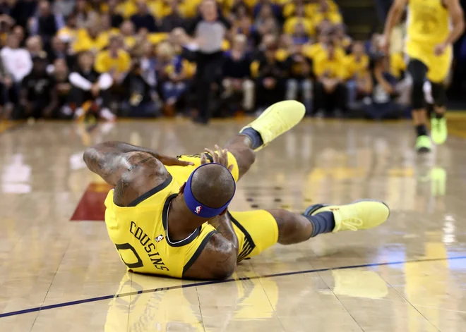 DeMarcus Cousins ima res smolo s poškodbami, tokrat si je ob padcu najbrž natrgal stegensko mišico, nato je s pomočjo osebja odšepal v garderobo, od koder se ni več vrnil. FOTO: AFP