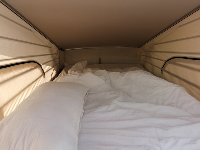 Pod stropom je zakonska postelja, ki jo lahko uporabljate le, če je streha dvignjena. Ko ležite, so občutki podobni kot v šotoru. FOTO: Gregor Pucelj