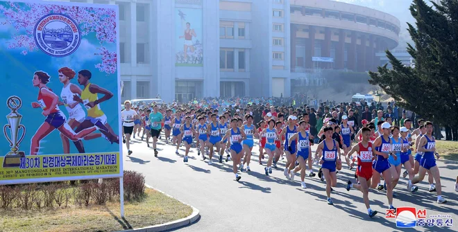 Navadnim turistom, ki po Pjongjangu samo hodijo, ne pa tečejo, ni dovoljeno brez nadzora pohajati pod znamenitostmi, kot je Slavolok zmage, maratonci pa imajo prosto pot. FOTO: Reuters