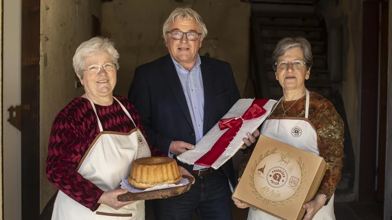 Fotografija: Mojstrici Veronika Aljančič (levo) in Barbara Pogačnik z Jernejem Jegličem, neutrudnim promotorjem sladice iz domače vasi. FOTO: Voranc Vogel