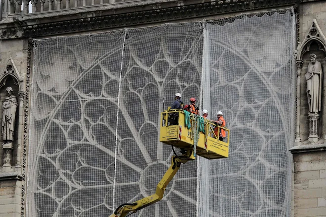 Ponjava je zgolj začasna rešitev, saj bodo nato postavili ogromen »dežnik«, ki bo trdnejši in bo zgradbo obvaroval pred vodo. FOTO: Kenzo Tribouillard/AFP