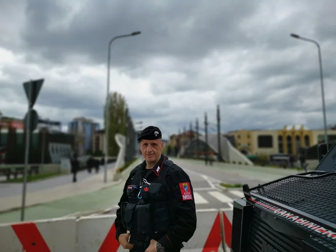 Na mostu čez reko Ibar, ki oba dela mesta povezuja, dan in noč stojijo oboroženi vojaki Natove misije Kfor z oklepljenimi vozili. "Tukaj je nevarno," pove italijanski vojak Riccardoi de Santis iz Genove. Foto Milena Zupanič/Delo