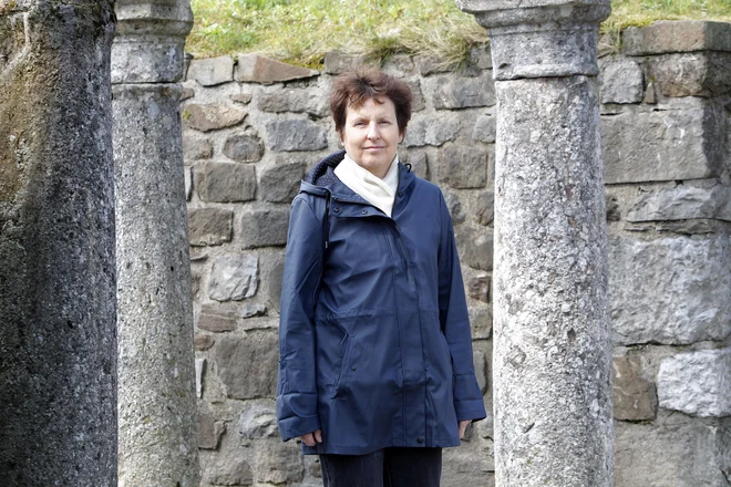 Arheologinja dr. Jana Horvat ob ostankih rimskega zidu v Ljubljani. Mimogrede je povedala, kako smotrno se je Jože Plečnik lotil njegove obnove. &raquo;Drobni kamenčki nakazujejo mejo med antičnim zidom in tistim, ki je bil do današnje višine dozidan.&laquo; FOTO: Mavric Pivk