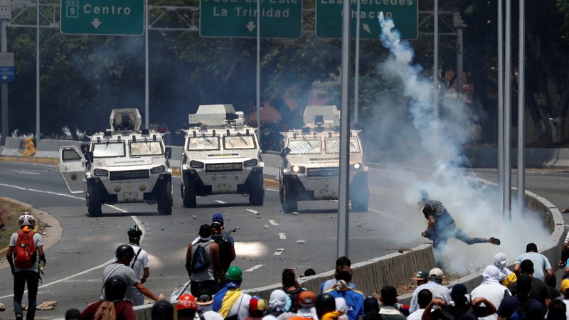 Fotografija: Opozicijski demonstranti so se spopadli z varnostnimi silami v bližini vojaškega letališča La Carlota v Caracasu. FOTO: Reuters