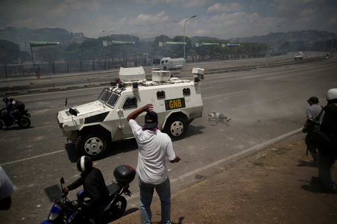 Oklepno vozilo je povozilo protestnika, stanje katerega ni znano. FOTO: Reuters