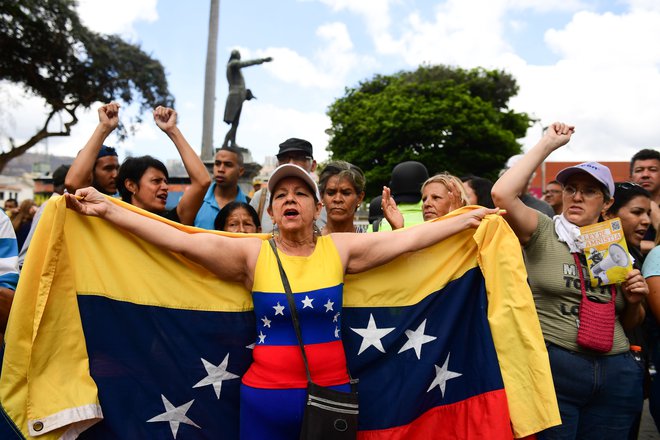 Nasprotnica predsednika Madure na protestih v eni izmed sosesk v Caracasu. FOTO: Ronaldo Schemidt/AFP