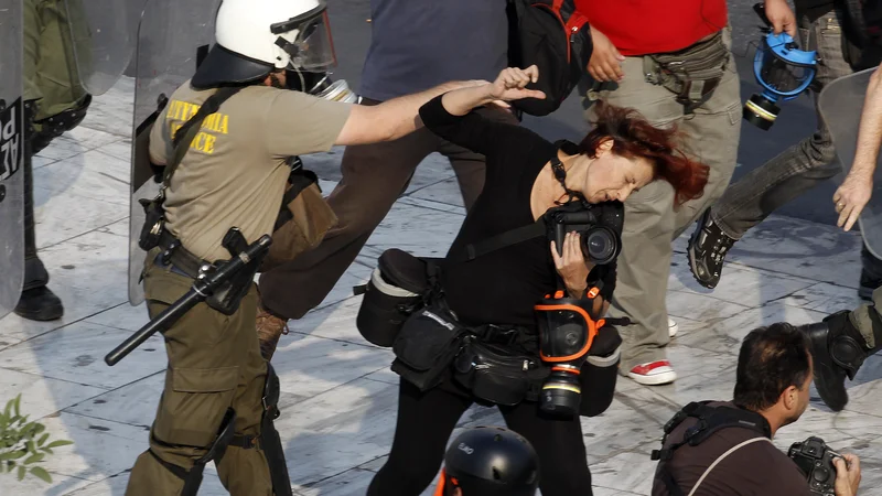 Fotografija: Grški policist je udaril fotoreporterkoTatianoBolari med demonstracijami v Atenah. Policisti so tisti dan napadli več novinarjev, ki so obravnavali proteste in ranili vsaj dva člana medijev. Foto Yannis Behrakis Reuters